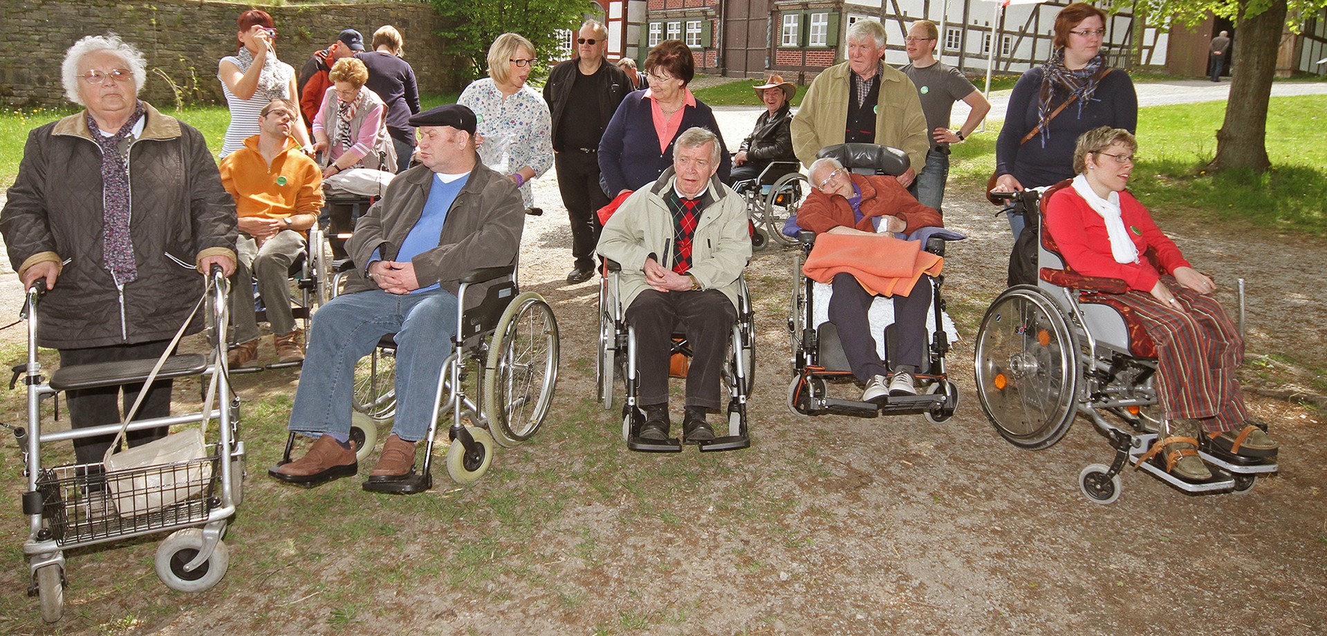 A group of 18 adults. Some are a bit older. Some use a walker or sit in a wheelchair.