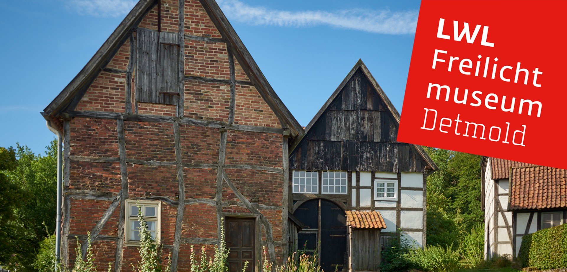 Zwei historische Häuser auf unserem Gelände im Paderborner Dorf. Das linke hat nur ein Fenster und eine Holztür im Dachstuhl.