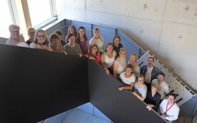 Die Mitarbeiter:innen des Referats Sammlung und Ausstellung stehen auf einer Treppe im neuen Museumsgebäude.