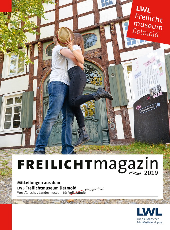 Titelbild des Freilichtmagazins 2019 mit einem Paar, das sich hinter einem Hut küsst. Im Hintergrund ist ein Fachwerkhaus.