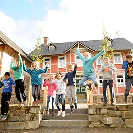 Eine Schulgruppe vor dem Hof Remberg, die gemeinsam in die Luft springen.