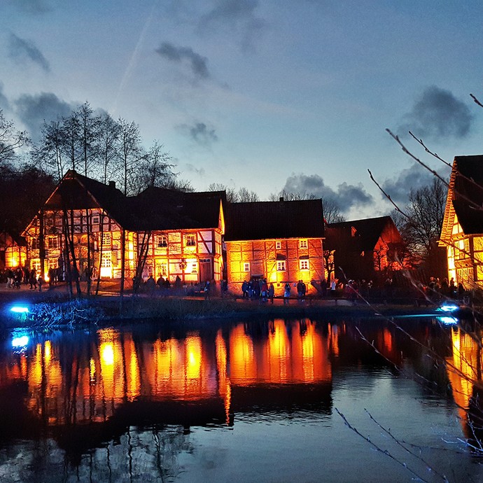 Die historischen Fachwerkhäuser rund um den Dorfteich sind in farbiges Licht getaucht. (öffnet vergrößerte Bildansicht)