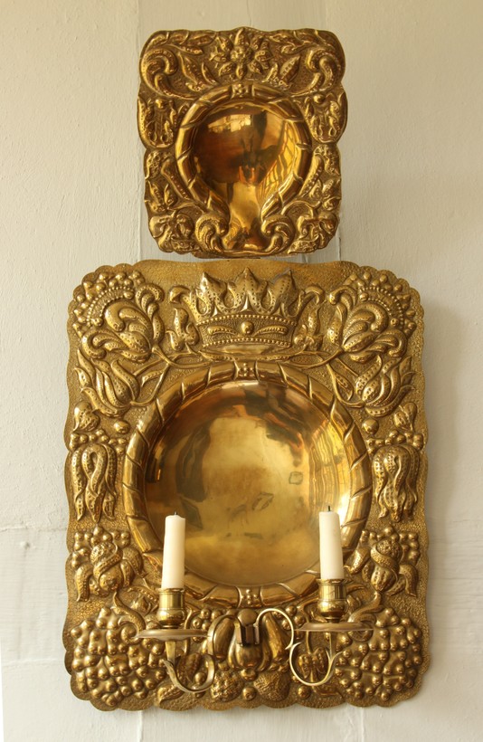 Goldene Platte mit einer Halterung für Kerzen. Die Ränder sind mit kleinne Ornamenten verziert.