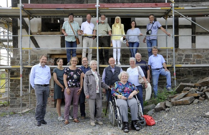 Gruppenbild mit Familie Stöcker und LWL-Mitarbeitern vor dem Haus Stöcker.