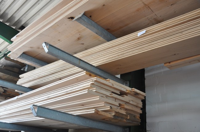 Fertige Dielenbretter für 150 m² Fußboden liegen auf Regalen.