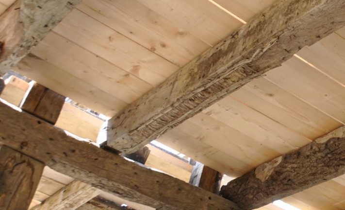 Am Deckbalken ist ganz deutlich die alte Plisterung, also ein Putzträger aus Stroh und Lehm zu erkennen. Hier war demnach nicht nur die Decke zwischen den Feldern verputzt, sondern auch die Deckenbalken.