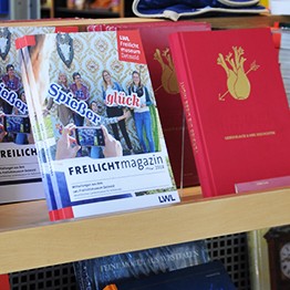 Das Freilichtmagazin und das Buch zur Ausstellung "vergiss die Liebe nicht" in einem Regal im Museumsshop