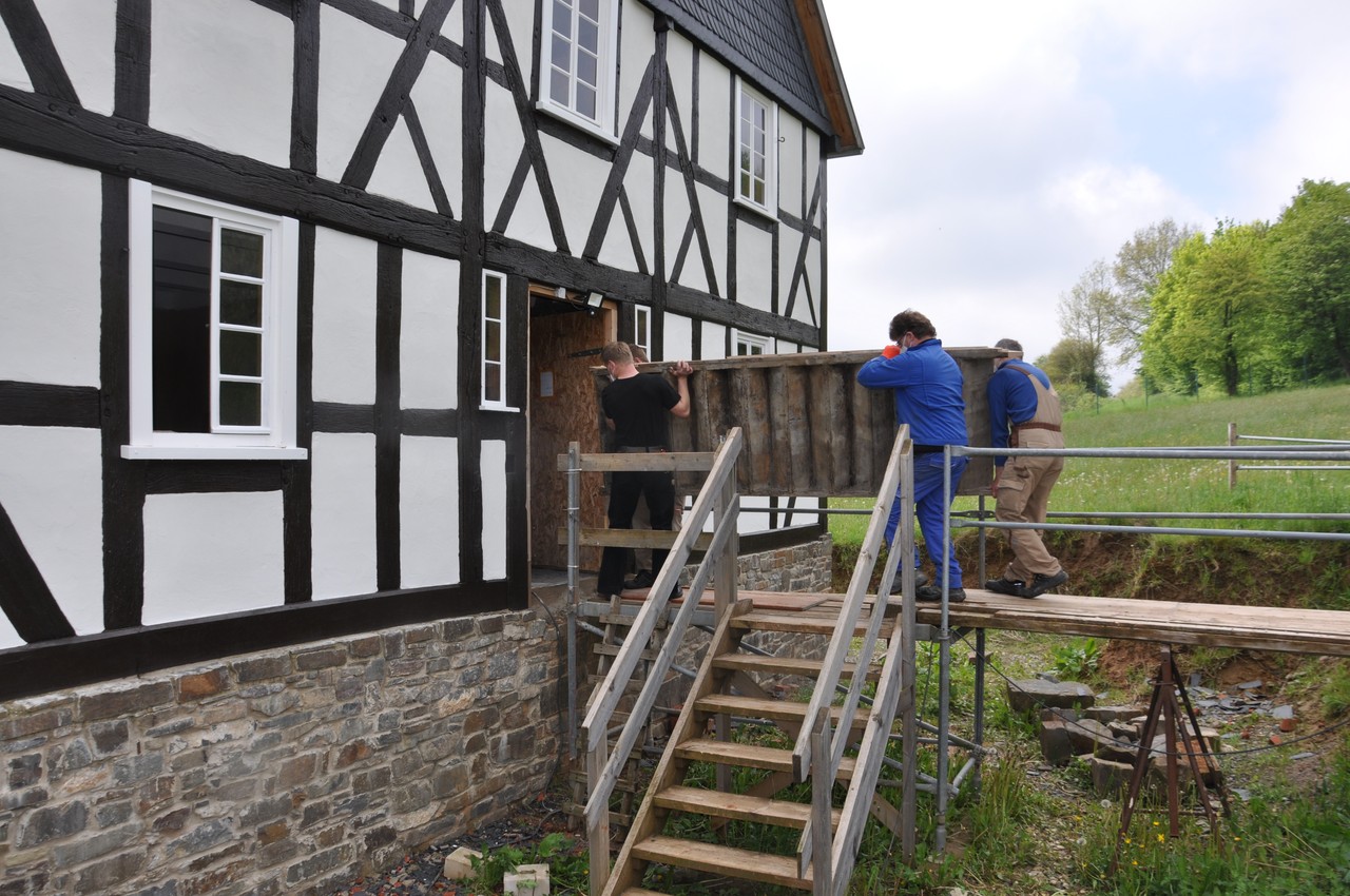 Vier Männer tragen die Treppe in das Haus Stöcker.