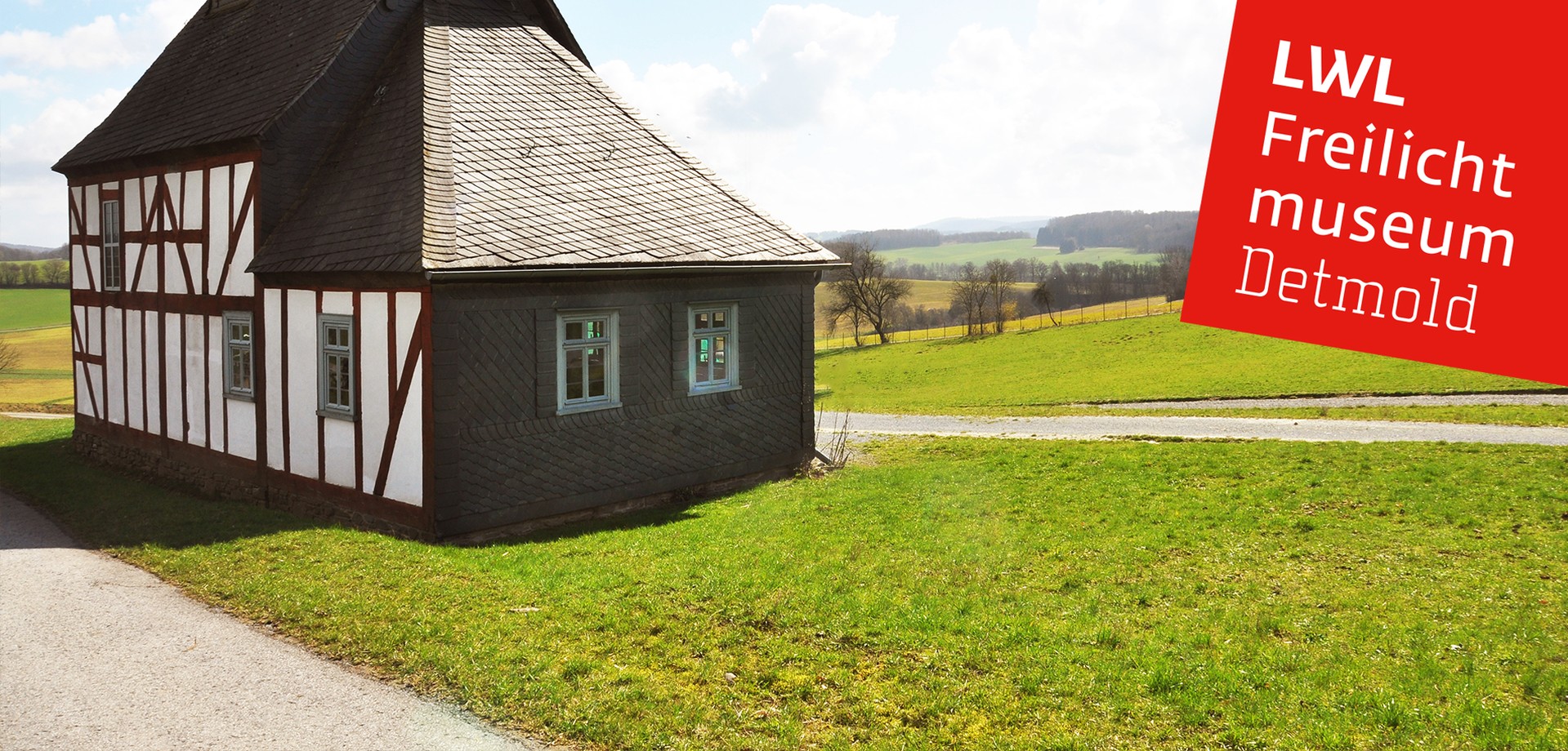 Die Kapellenschule Werthenbach. Dahinter eine Wiese und weite Felder