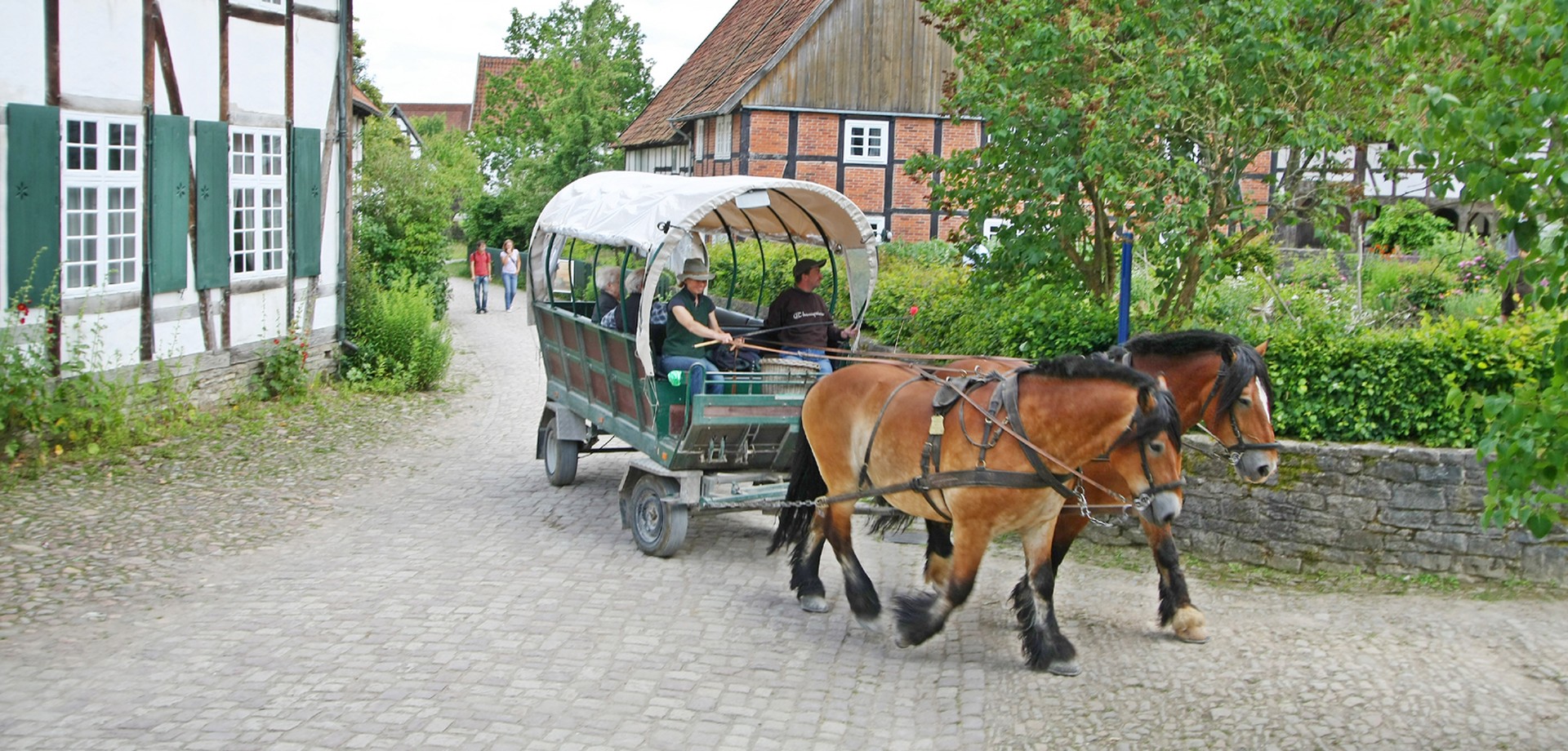 Eine von zwei Pferden gezogene Kutsche fährt durchs Paderborner Dorf.
