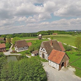 Ein Teil des Paderborner Dorfes aus der Luft, im Hintergrund Wiesen, Felder und Wälder.