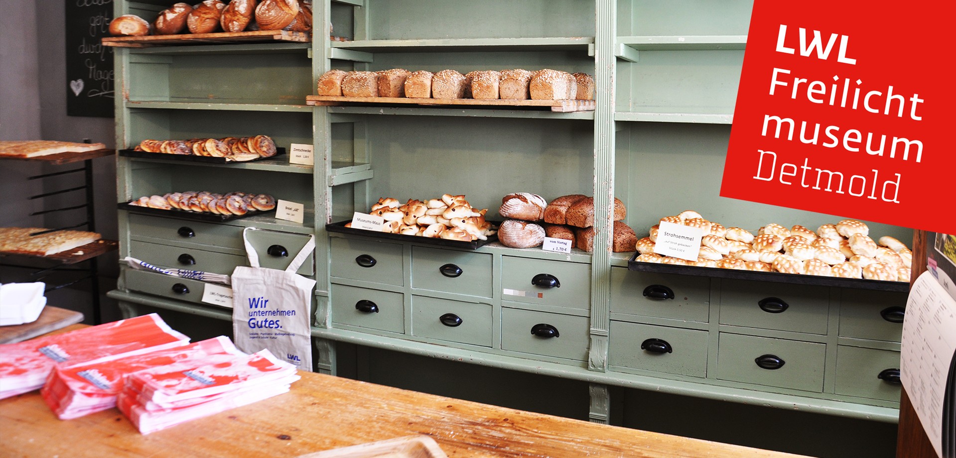 Den Verkaufsraum der Bäckerei. In den Regalen liegen Backwaren wie Brote und Kuchen.